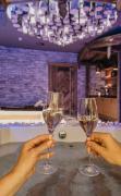 2 Personen mit einem Sektglas in der Hand im Whirlpool des Hotels Alpine Palace